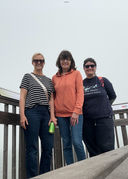 Three women stand on the end of a boardwalk overlooking the San Francisco Bay. They are an IBCLC, an OTD, and two Doulas