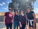 Four women stand in front of a dry hill with a tree in the background, they are all wearing sunglasses. They are Perinatal Providers which include two doulas, a personal trainer, and a chiropractor.