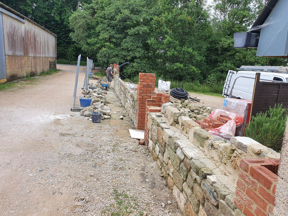 During - Progress on coursed wall with brick quoins.