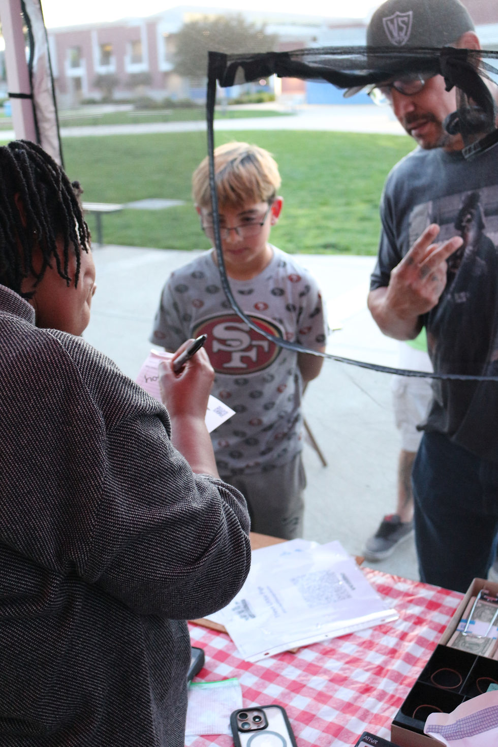 People placing an order at the pop up booth for Bay Area BBQ food vendor Three Little Pigs