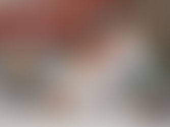 Child and adult using a laptop together at a table with colorful letters, in a cozy room with a star pillow and festive bunting in the background.