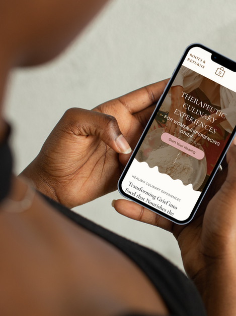 African American woman holding an Iphone that is displaying the custom website for Roots & Returns