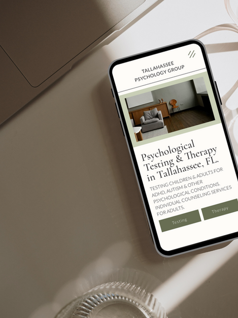An iPhone sits on a desk and the website displaying is a custom website for Tallahassee Psychology Group