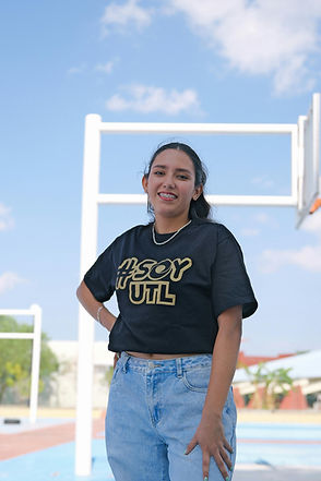 Smiling young woman in black 'SOY UTL' t-shirt outdoors