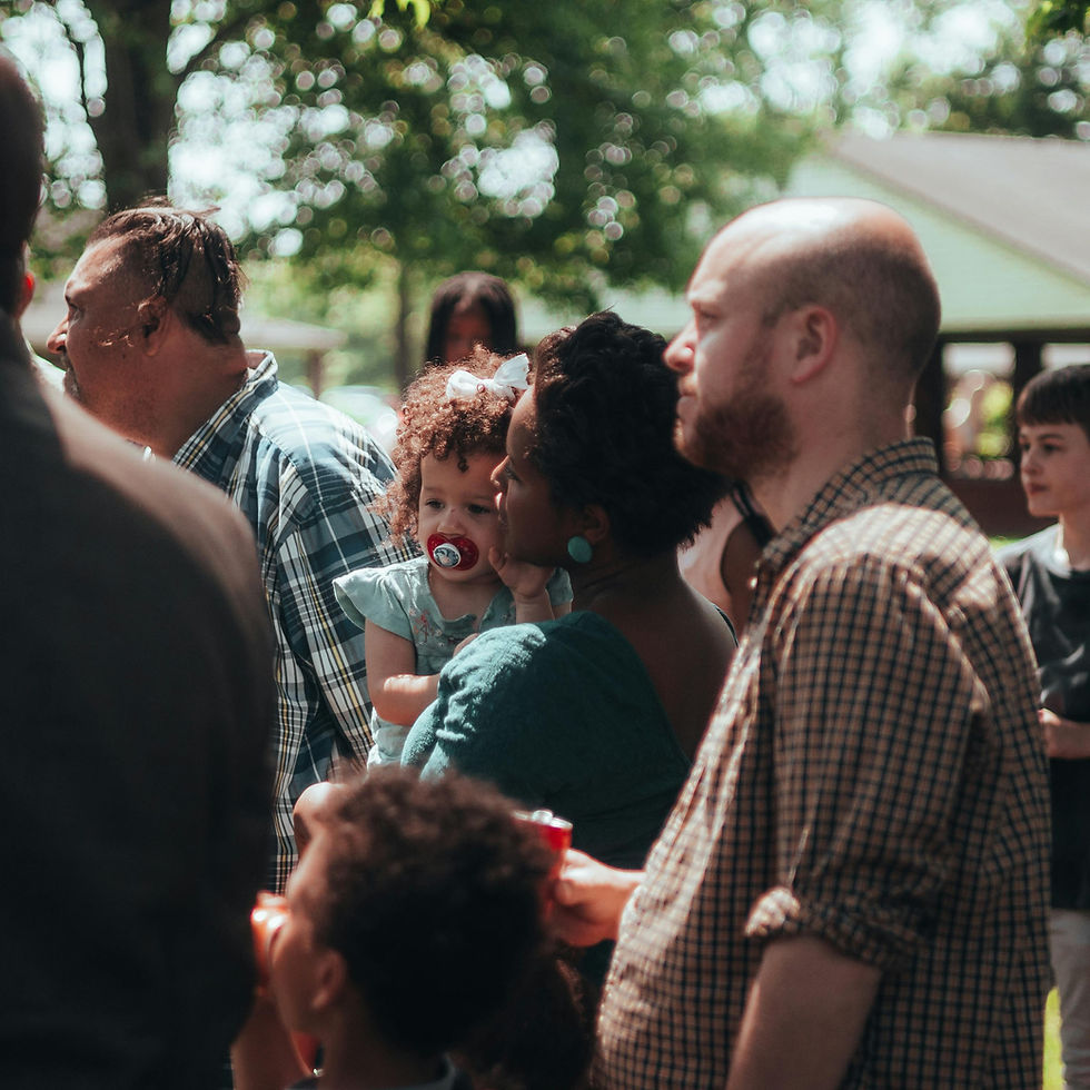 People gathered outdoors, including a baby with a pacifier.