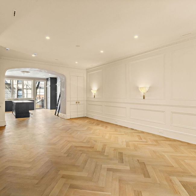 Wide parlor view leading through an arched opening to the custom kitchen.