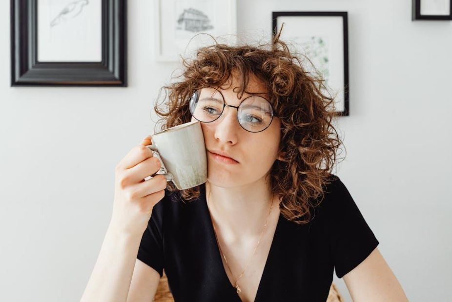 https://www.pexels.com/photo/curly-haired-woman-holding-a-coffee-mug-7681199/