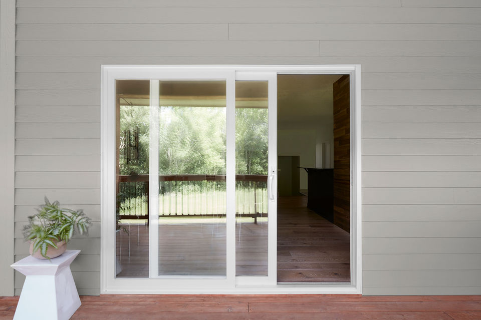 Patio door with large glass panels opening to an outdoor patio and backyard living space