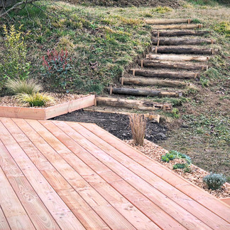 Escalier en rondins et massif végétalisé menant à la terrasse en bois – aménagement extérieur en Hau