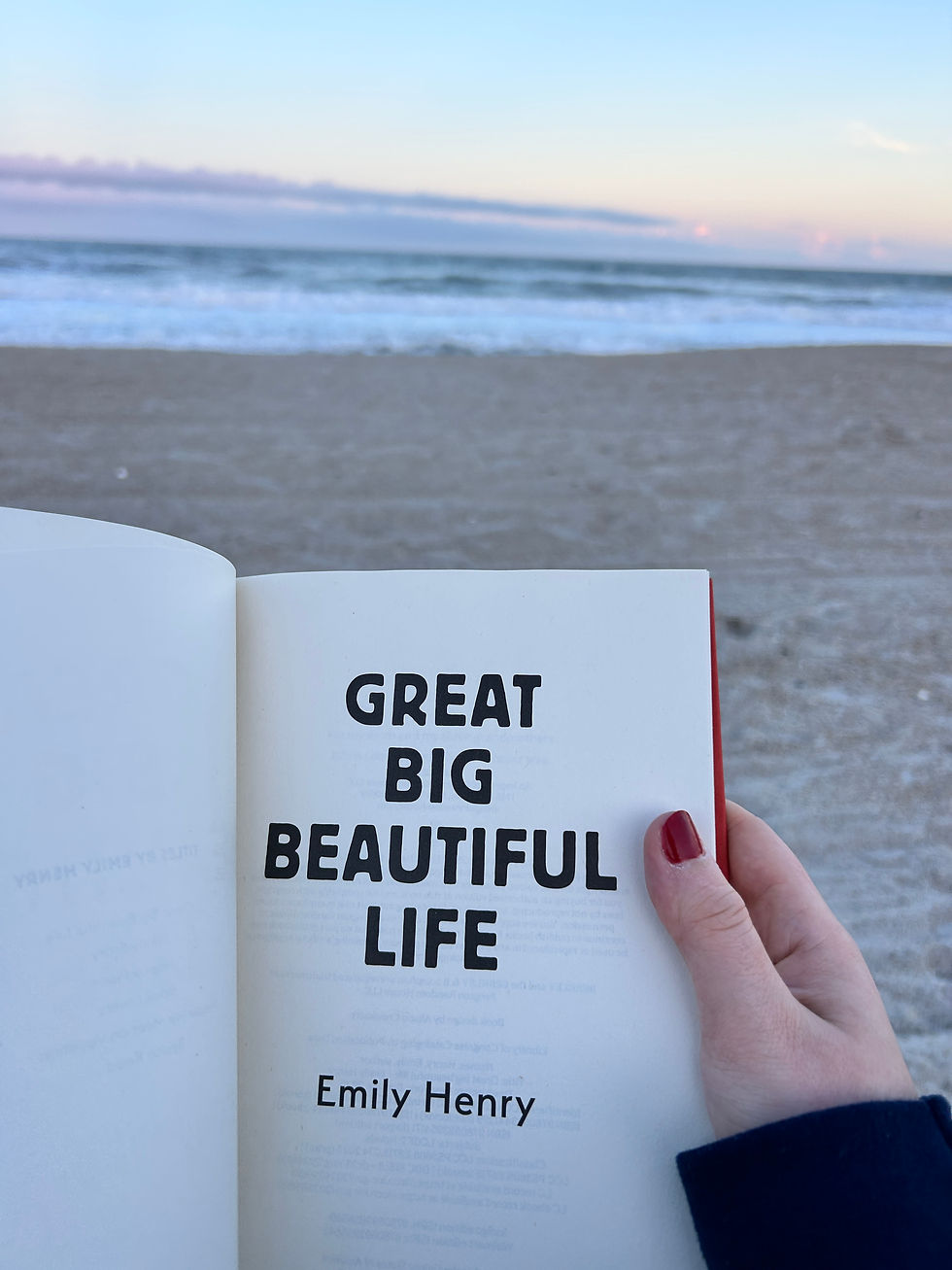 Reading Great Big Beautiful Life by Emily Henry at the beach.