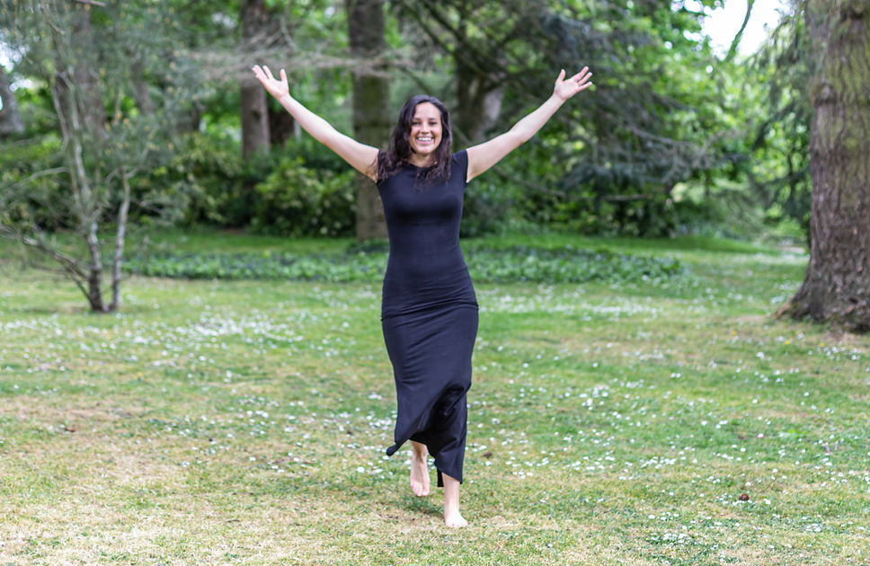 Portrait debout en nature, bras grands ouverts, sourire