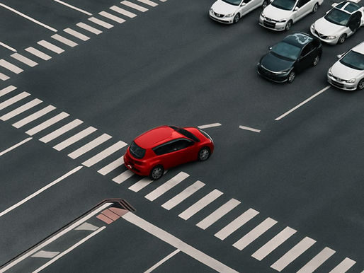 Aerial view of a busy intersection with one car turning while others are stationary, symbolising responsiveness.