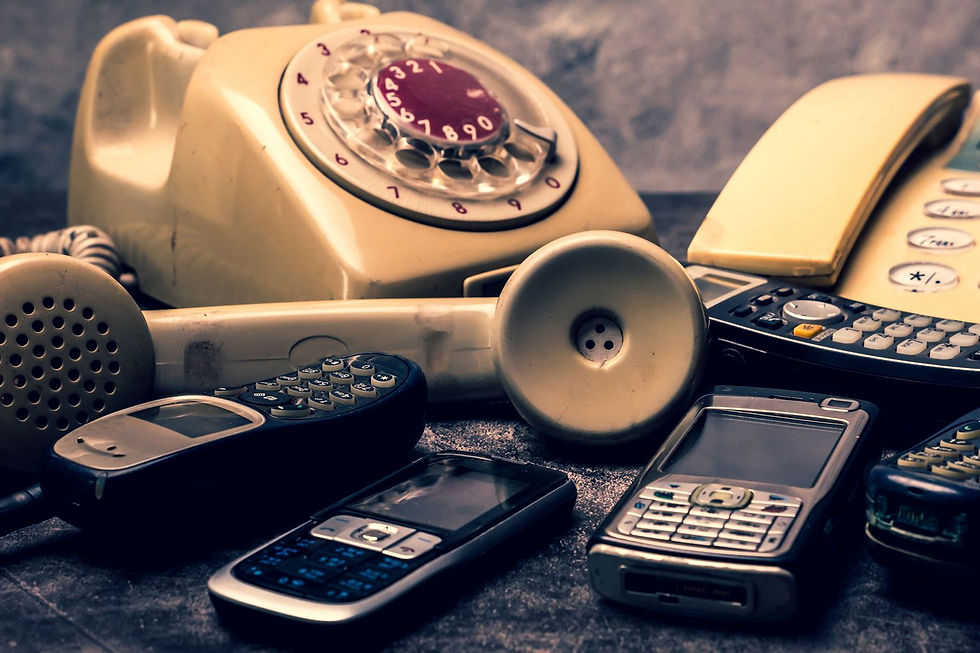 A pile of antique, damaged, and disconnected telephones with tangled wires, symbolizing a complete breakdown in strategic communication between leadership and operational teams.