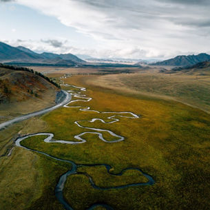 Overhead view of a windy river system next to a clean, structured road, symbolising organisational clarity.