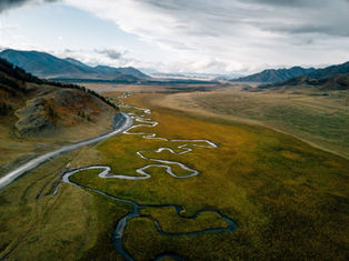 Overhead view of a windy river system next to a clean, structured road, symbolising organisational clarity.
