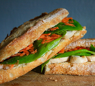 un sandwich avec filet de poulet avec salade et carottes râpées