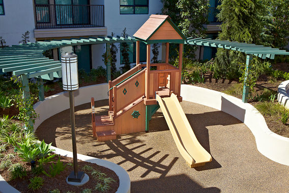 Overview of wood play fort in patio surrounded by garden bed
