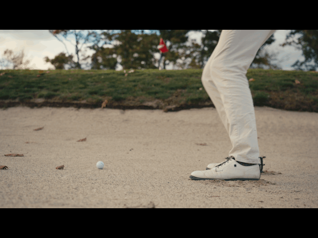 Golfer playing a bunker shot, from the TaylorMade spec commercial.