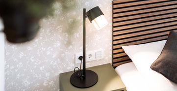 Nachttisch mit Lampe und Bett in Wien