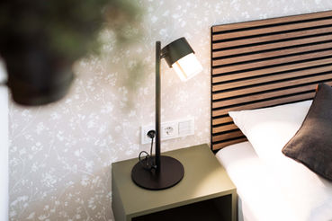 Nachttisch mit Lampe und Bett in Wien