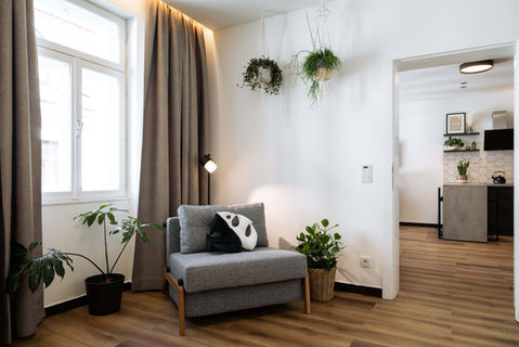 Sofa mit vielen Pflanzen und Küche im Hintergrund Urban Jungle Apartments Vienna