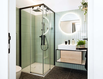 Badezimmer mit Dusche und Spiegel in den Urban Jungle Apartments