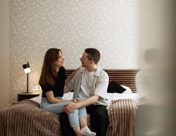 Pärchen sieht sich auf einem Bett verliebt an