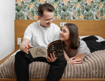 Pärchen liest ein Magazin in einem Bett der Urban Jungle Apartments