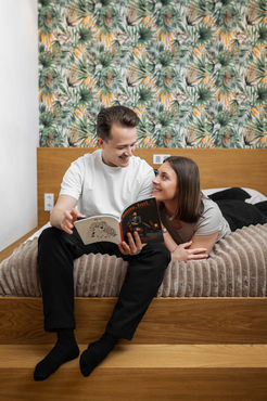 Pärchen liest ein Magazin in einem Bett der Urban Jungle Apartments