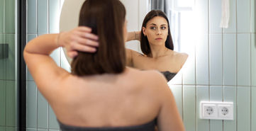 Junge Frau vor Badezimmerspiegel