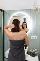 Junge Frau vor Badezimmerspiegel