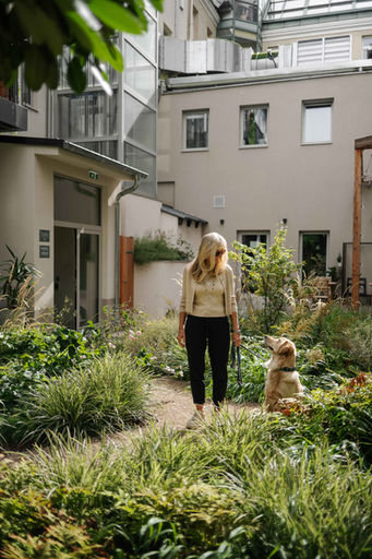 Frau mit Hund im Urban Jungle Garden