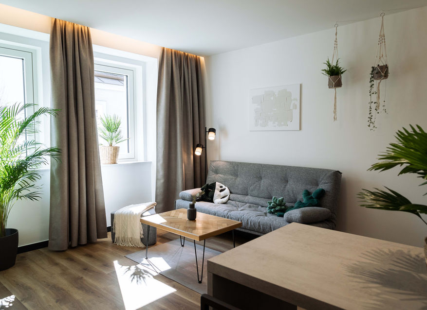 Living room with lots of plants in the Urban Jungle Apartments