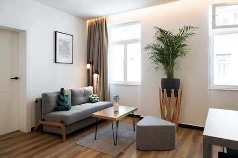 Wohnzimmer Urban Jungle Apartments Wien mit Pflanzen, Sofa und Couchtisch