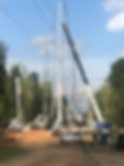 Heavy cranes install power transmission tower during electrical line construction.