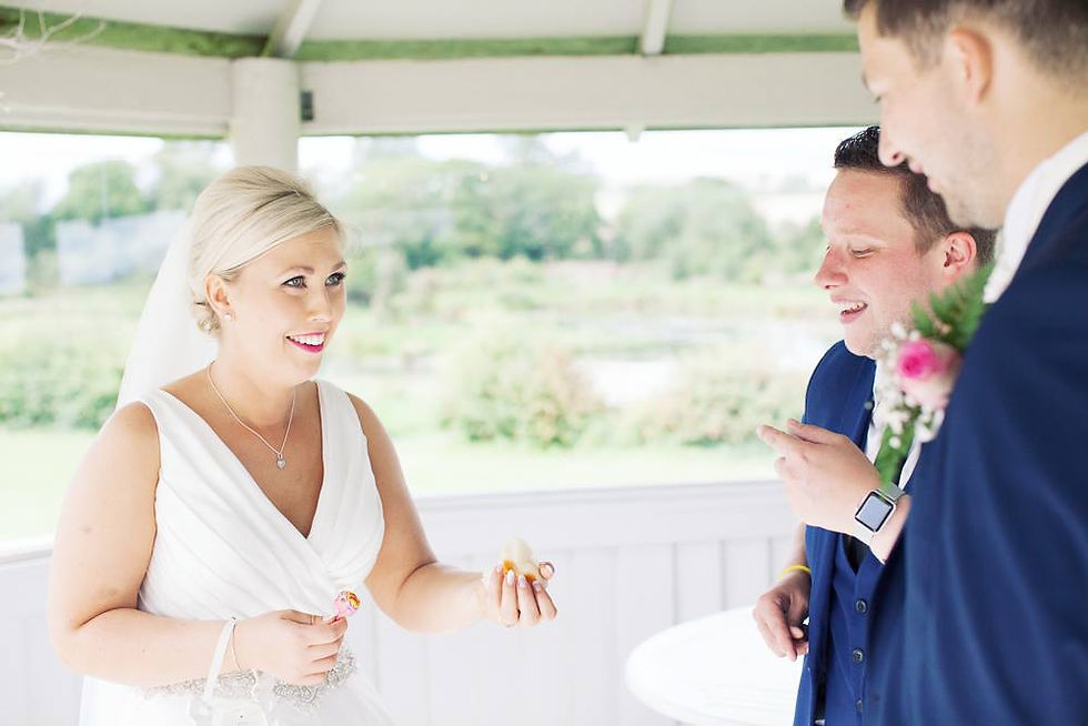 A magician entertains a bride at her wedding. She is wearing a white dress