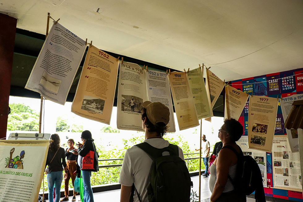 Na foto podemos ver pessoas visitando uma exposição histórica.