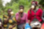 Three women sitting and drinking from mugs outdoors