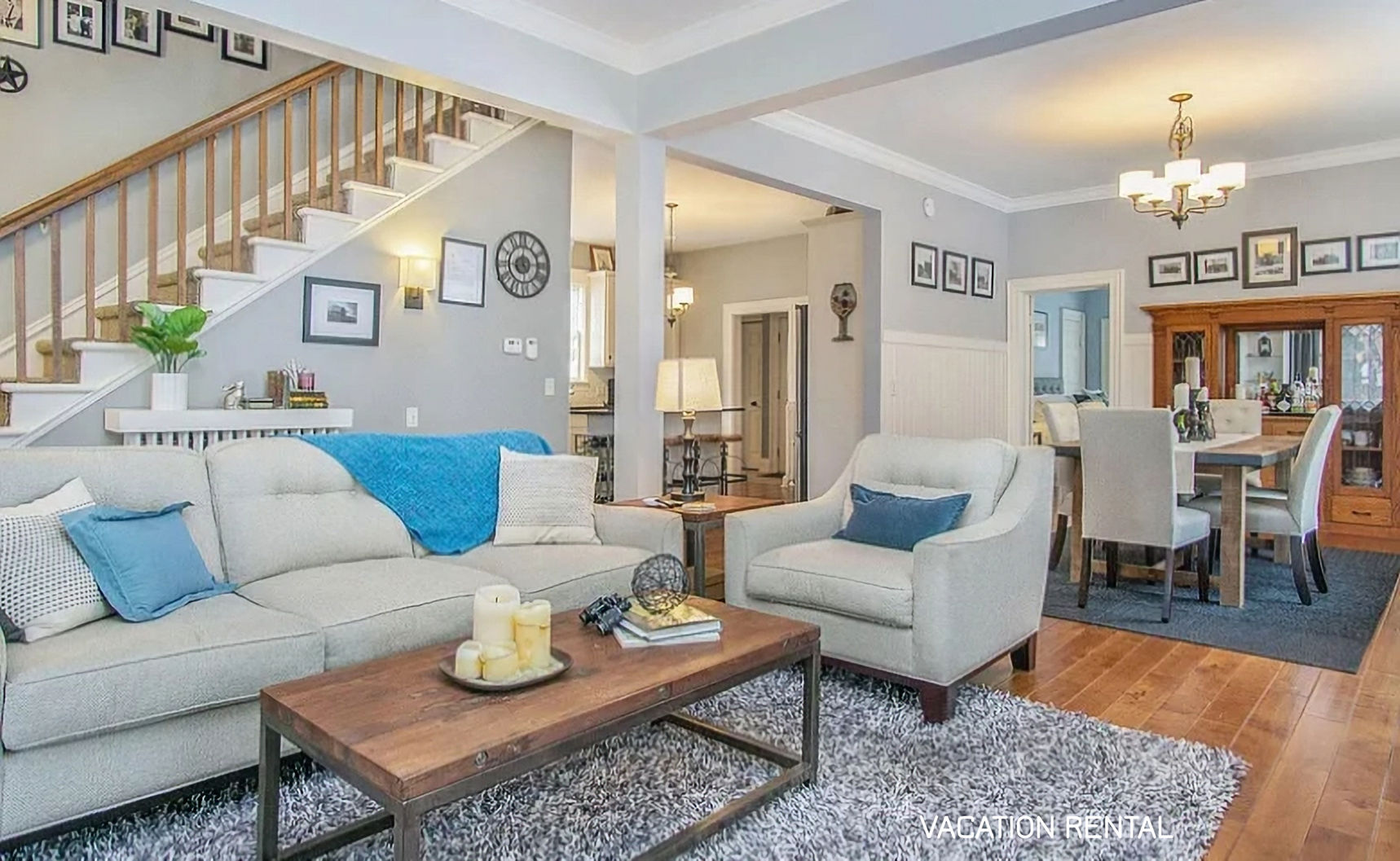 Farmhouse with light sofa with blue accents and dining table with six chairs