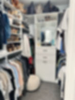 Master closet organized by sleeve length and color, with stacked shoes, handbags on upper shelves, a