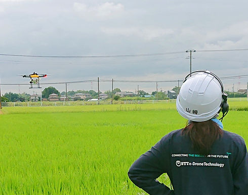 農業ドローンとその運用を確認する人物