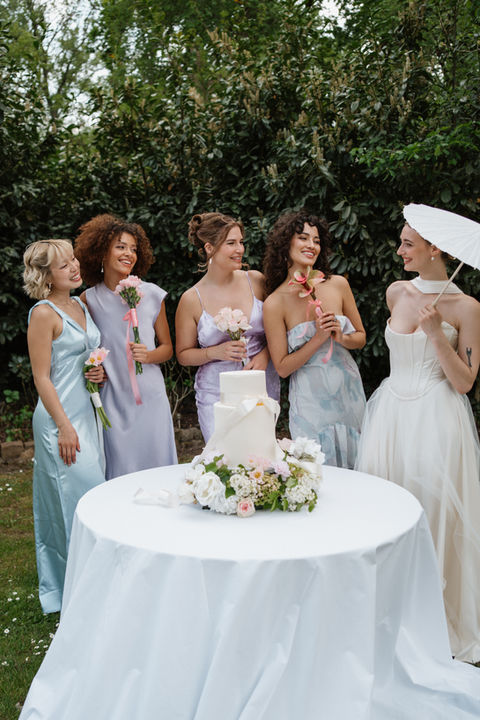 Braut unterhält sich mit ihren vier Brautjungfern, die in Blautönen gekleidet sind. Diese freuen sich sehr über das, was die Braut ihren erzählt