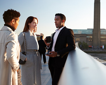 A group of colleagues communicating in English together in London.