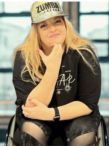 Image of Tennille, a white woman with long strawberry blond hair sitting in her wheelchair.