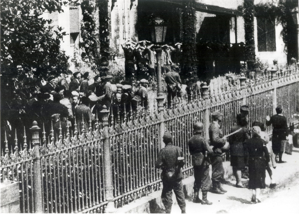 Hostages gathered in front of the mairie in Mussidan on 11 June 1944. Those on the left would be released. Those on the right with their hands in the air would be shot that evening. (Collection Patrice Rolli)