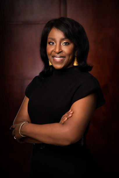Corinne Houmou Ormon Directrice Antenne Cote d'Ivoire BRVM en robe noir devant une porte en bois
