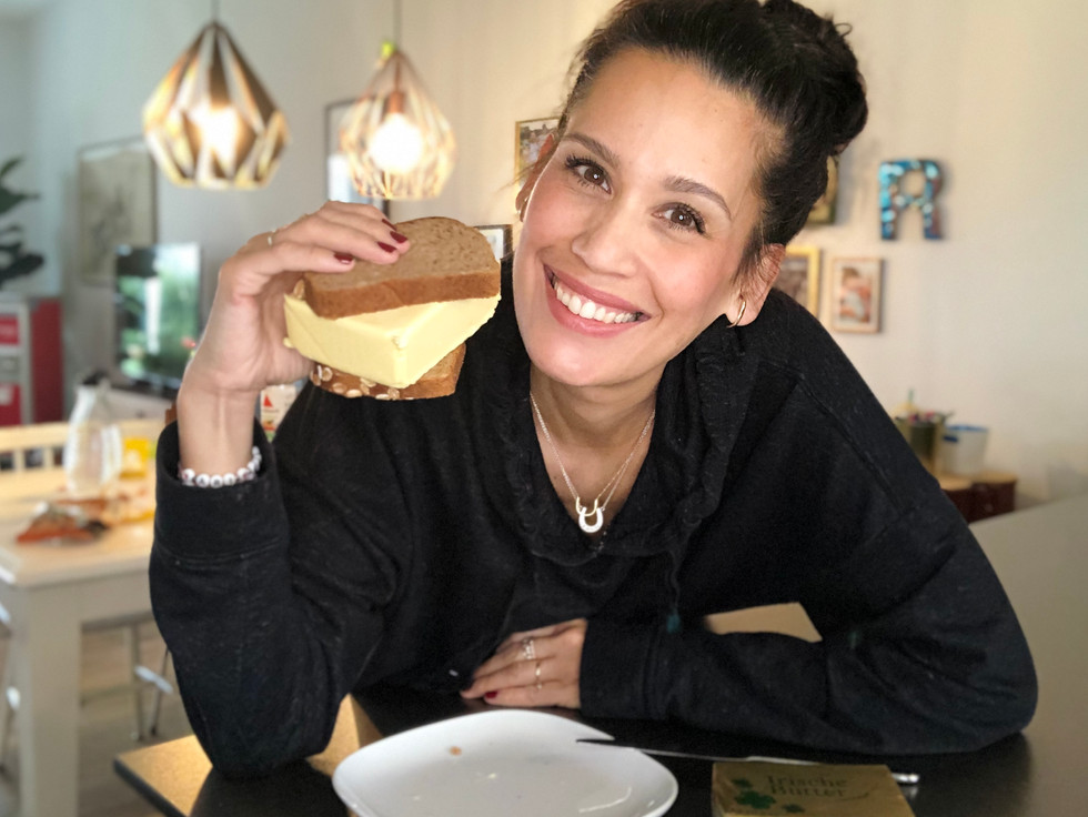 Frau hält ein Sandwich mit einer Packung Butter dazwischen