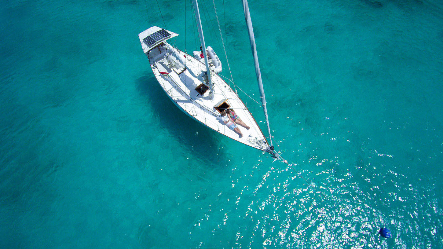 Voilier au mouillage sur une eau turquoise cristalline, sortie en mer