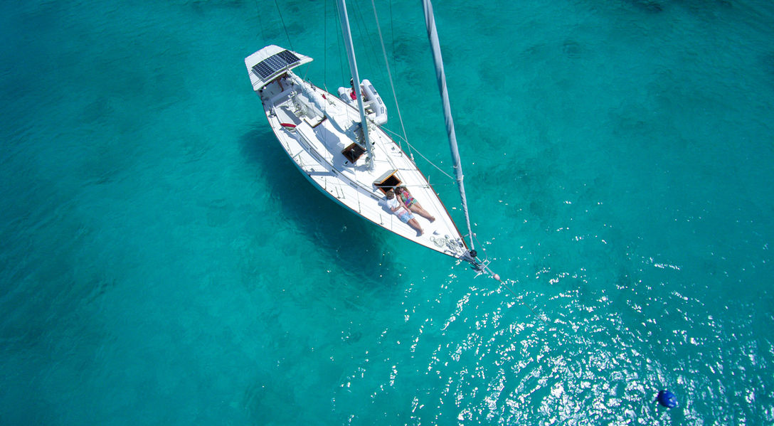An aerial picture  of a top view of a sailing boat at the sea  taken by the drone