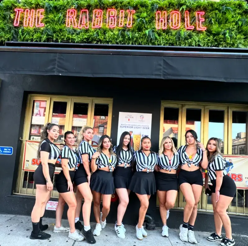 Front of The Rabbit Hole Astoria, featuring many of the bartenders dressed like referee's